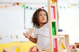 Child learning how to properly stack blocks representing the learn by doing mentality.